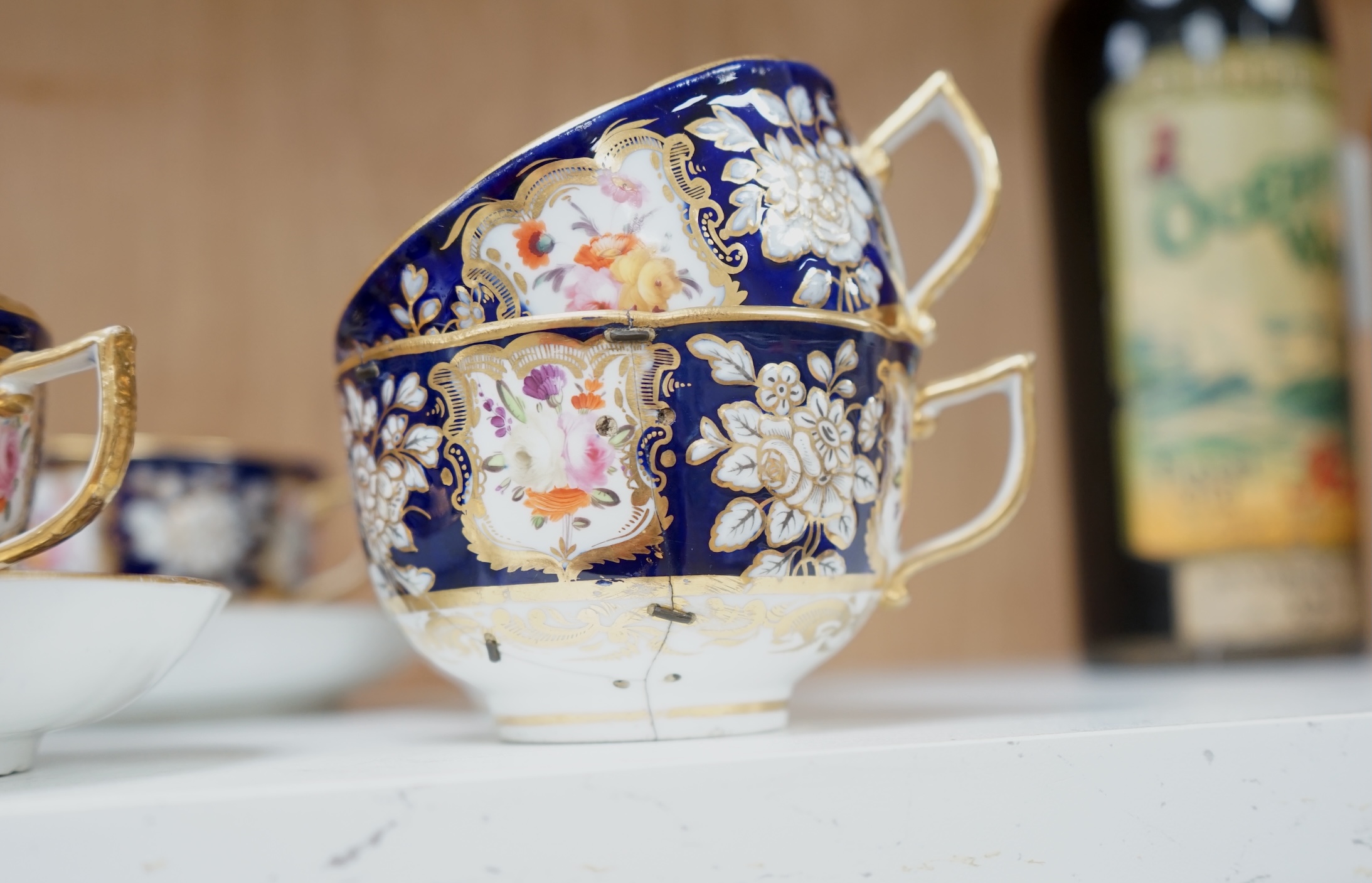 An early 19th century English porcelain tea service, possibly Coalport, moulded in low relief with floral reserves and cobalt blue border. Condition - varies